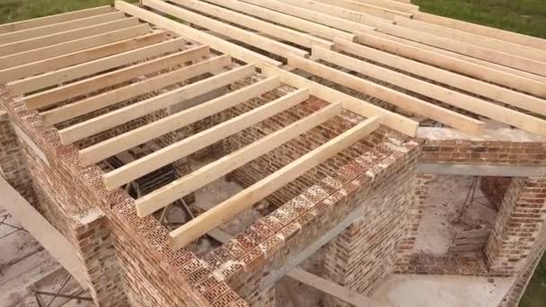 Letecký pohled na cihlový dům s dřevěným stropním rámem ve výstavbě. - Záběry, video