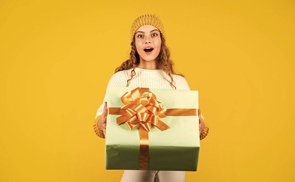 Dear santa. surprise. Happy little smiling girl with christmas gift box. kid hold present box yellow background. Happy Christmas and New Year. Christmas gift in hand. Christmas concept - Fotoğraf, Görsel