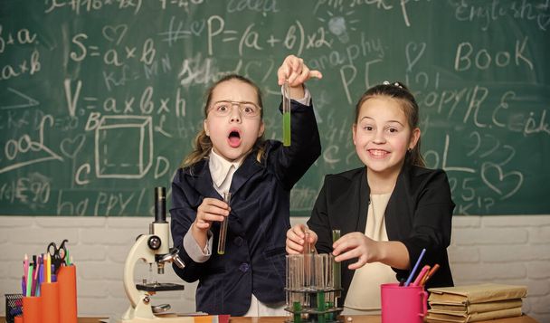 Be careful performing chemical reaction. Basic knowledge of chemistry. Girls study chemistry. Make studying chemistry interesting. Microscope and test tubes on table. Educational experiment concept - Foto, imagen