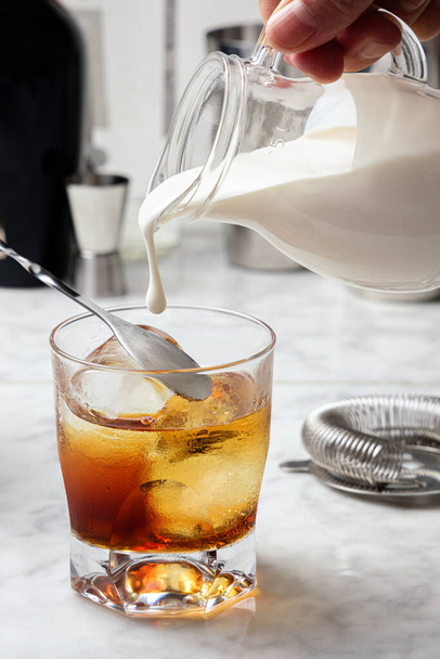 Witte Russische cocktailbereiding. Crème in het glas gieten - Foto, afbeelding
