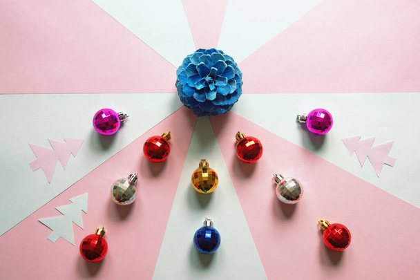 Helle Weihnachtskugeln und blauer Tannenzapfen auf Papierhintergrund. Flache Lage, Kopierraum - Foto, Bild