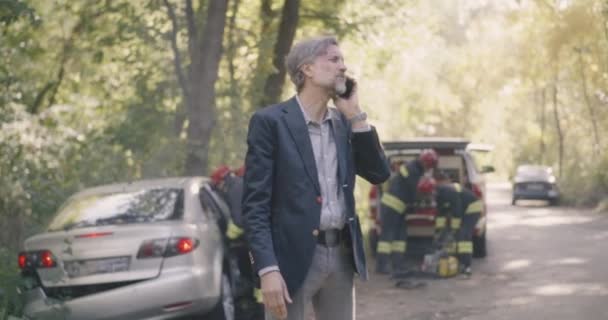 Ώριμος άνδρας που μιλάει στο smartphone μετά από τροχαίο ατύχημα - Πλάνα, βίντεο