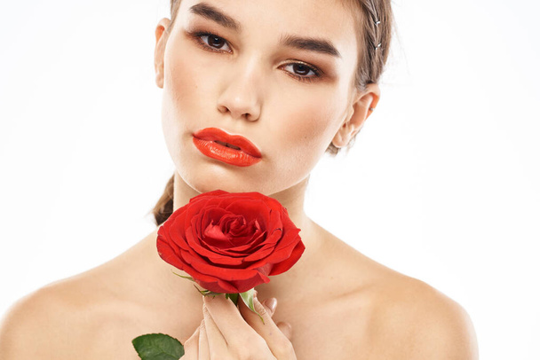 Belle femme avec rose rouge près du visage maquillage épaules nues portrait - Photo, image