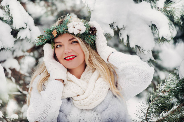 PPortrait of a woman in white clothes in a cold winter forest. Girl with a wreath on her head in a snow-covered winter forest. - Foto, imagen