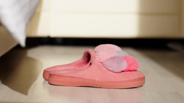 A man gets out of bed in the morning and puts on womens pink slippers - Footage, Video