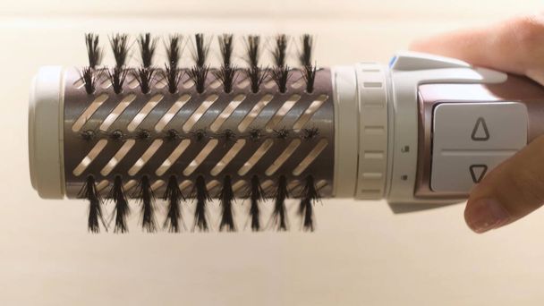 美容師の特別な取り外し可能なノズルを閉じます。コンセプト。髪の乾燥のための女性の自動機械、ヘアスタイリングのための専門的なツール. - 写真・画像