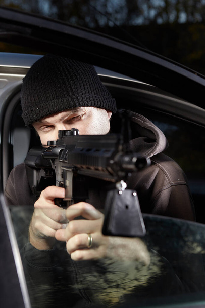 Man with assault carbine waiting for his wictim inside car - Фото, зображення