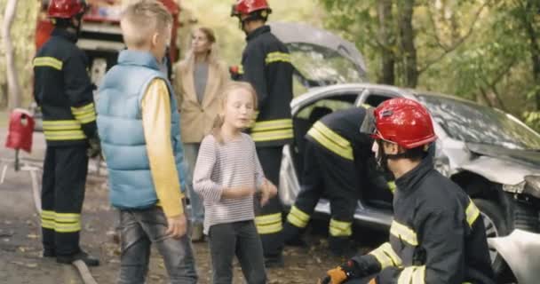 Palomiehet kuulustelevat perhettä auto-onnettomuuden jälkeen - Materiaali, video