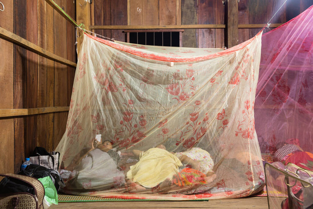 Phnom Penh, Phnom Penh / Cambodia - October 7th 2016: Image of a Khmer rural people in the countryside inside of a mosquito net. Resting, sleeping.  - Photo, image