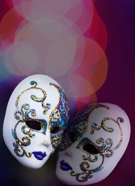 zwei schöne Masken auf buntem Hintergrund mit Bokeh - Foto, Bild