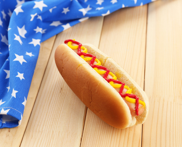 Tasty hot dog on wooden table - Фото, изображение