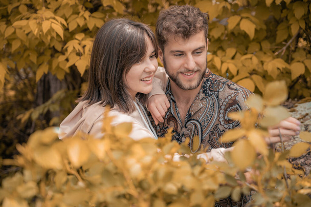 ommon passion of young couple during their trip. Warm autumn tones. Love conversation between people in love. Happiness in the air. Enchanted look of people in love. Picking berries together. - Photo, image