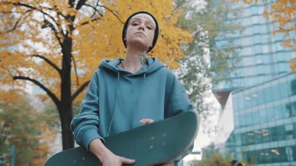 Lázadó tinédzser, lány, ősszel a városi parkban tartja a táblát. - Felvétel, videó