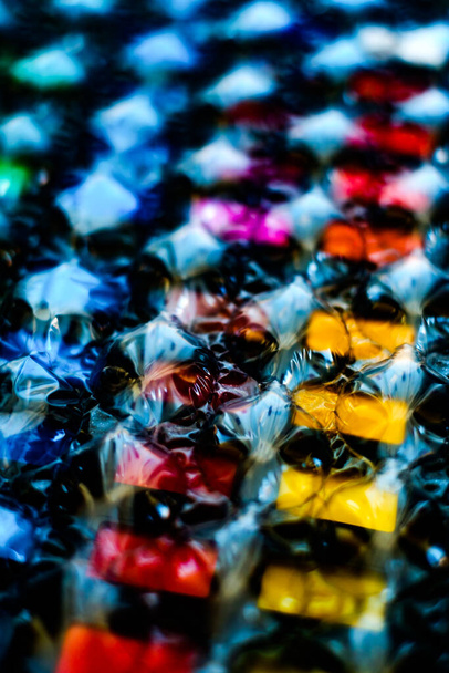 abstraktní vícebarevné pozadí vytvořené barevným obrazem přes fólii plastové bubliny - Fotografie, Obrázek