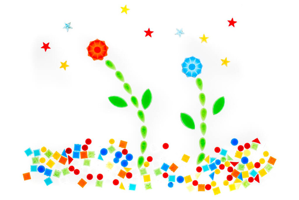 цветы из цветных пластиковых фигур на белом фоне - Фото, изображение