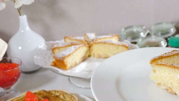 Servire pezzo di deliziosa torta sul piatto in hotel. Deliziosi dolci freschi serviti sul piatto per colazione con caffè. Splendidamente decorato tavolo da banchetto catering. 4K video - Filmati, video