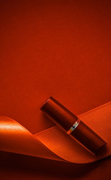 Luxury huulipuna ja silkkinauha oranssi loma tausta, meikki ja kosmetiikka flatlay kauneuden tuotemerkin tuotesuunnitteluun - Valokuva, kuva