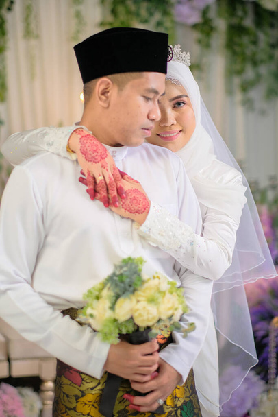 Εσωτερική γυρίσματα για γάμο Μαλαισίας, η νύφη και ο γαμπρός φορώντας Μαλαισίας παραδοσιακό πανί στην τελετή του γάμου. Χαρούμενη & οικογενειακή έννοια - Φωτογραφία, εικόνα