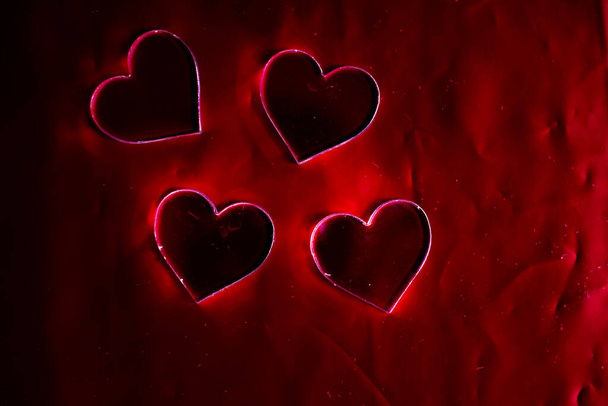 forma de corazones de plástico sobre fondo rojo - Foto, imagen
