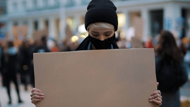 Protesta y manifestaciones. mujer rebelde con mascarilla impactante  - Foto, imagen