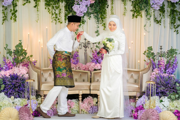 Εσωτερική γυρίσματα για γάμο Μαλαισίας, η νύφη και ο γαμπρός φορώντας Μαλαισίας παραδοσιακό πανί στην τελετή του γάμου. Χαρούμενη & οικογενειακή έννοια - Φωτογραφία, εικόνα