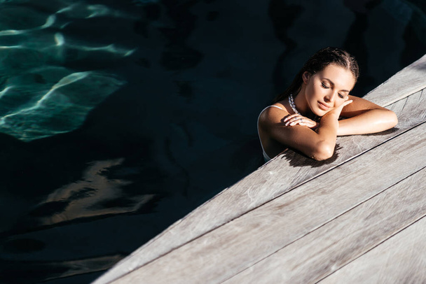 beautiful long hair female model posing by the pool, outdoor portrait - Foto, Bild
