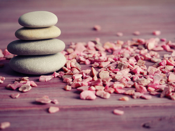 Дзен камни на деревянном фоне, рядом с розовыми камнями, концепция спокойствия. - Фото, изображение