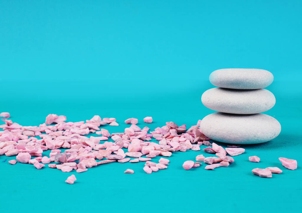Zen-Steine auf blauem Hintergrund neben rosa Steinen, das Konzept der Ruhe. - Foto, Bild