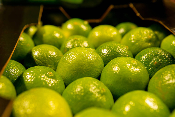 naturalne limonki owocowe w sklepie spożywczym.Dział rynku rolnego w supermarkecie. - Zdjęcie, obraz