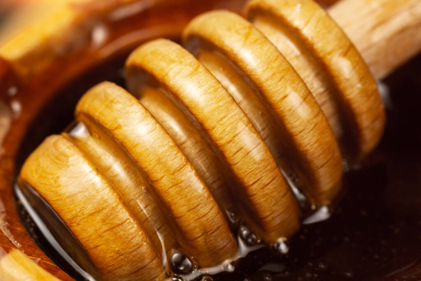 Honey in a wooden bowl. Close-up macro. Healthy organic honey. selective focus - Foto, Bild