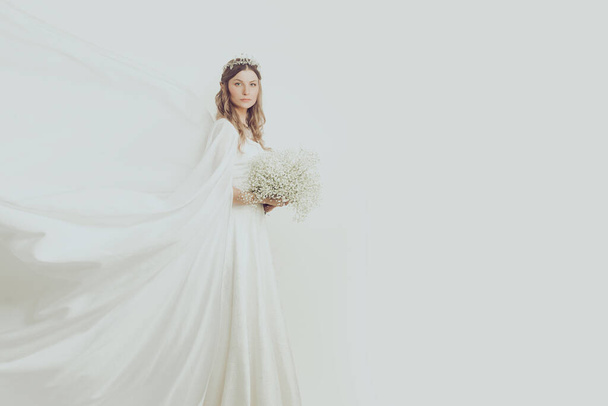 Красивая женщина в белом шелковистом вечернем платье на белом фоне. Таинственная эльфийская колдунья принцесса костюм персонажа Хэллоуина - Фото, изображение