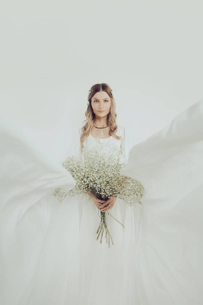 Чарівна жінка-ельф у вечірній сукні з білими квітами. Таємничий одинадцятирічний костюм персонажа Хеллоуїна
  - Фото, зображення