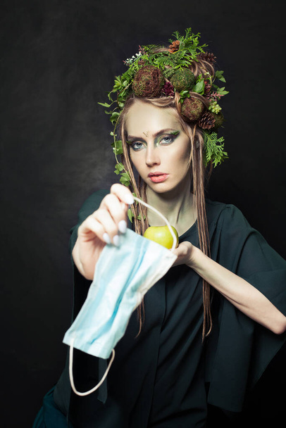 Residuos durante COVID-19. Mujer de la naturaleza con mascarilla de un solo uso usado. Contaminación ambiental y protección del medio ambiente - Foto, Imagen