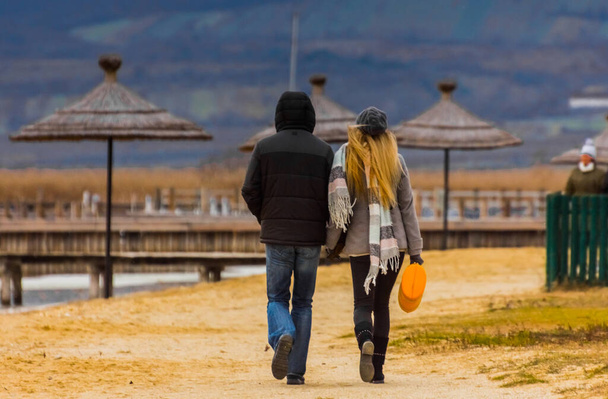 homem e mulher enquanto caminhava no lago no outono com sol - Foto, Imagem
