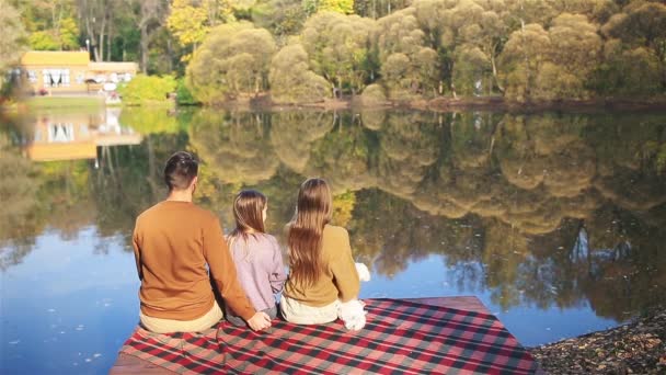 Gelukkige familie op een picknick in het park in de herfst - Video