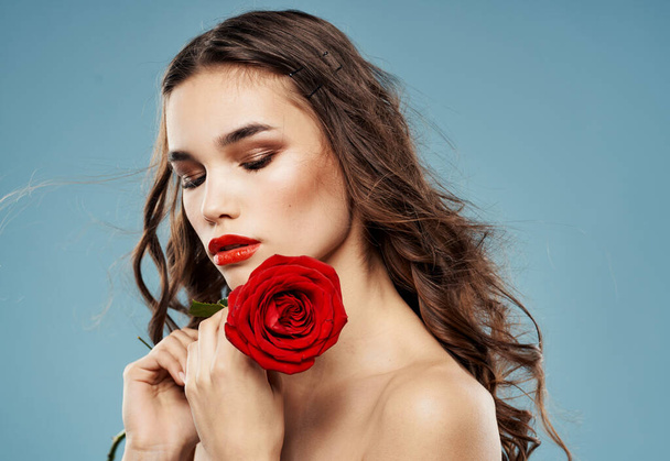 Παθιασμένη γυναίκα με κόκκινο τριαντάφυλλο σκιά ματιών στα βλέφαρα μπλε φόντο περικοπεί άποψη - Φωτογραφία, εικόνα