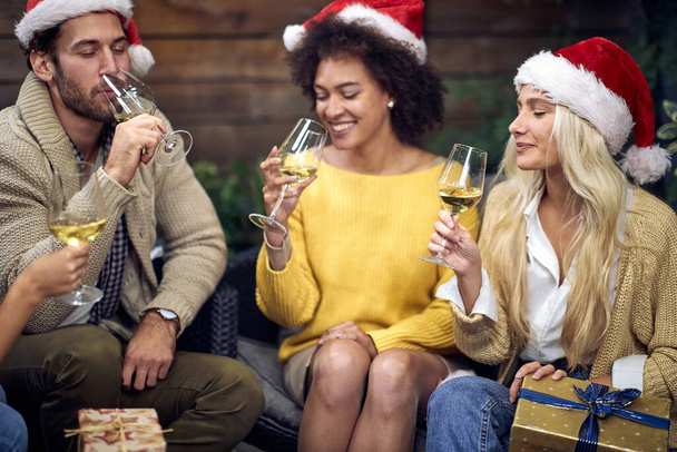 Group of happy young people celebrating Christmas or New Year together; House party concept - Photo, Image