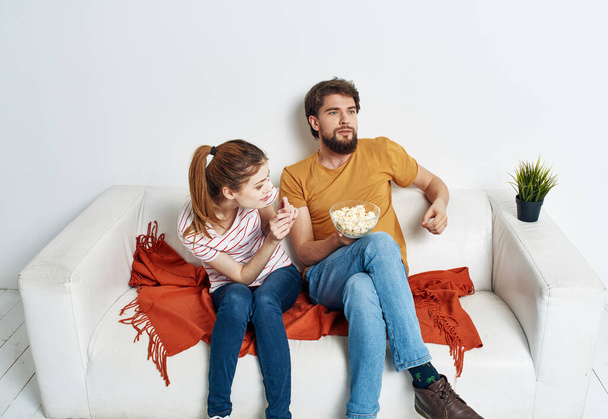 Άνδρας και γυναίκα στον καναπέ με ποπ κορν βλέποντας τηλεοπτικές εκπομπές - Φωτογραφία, εικόνα