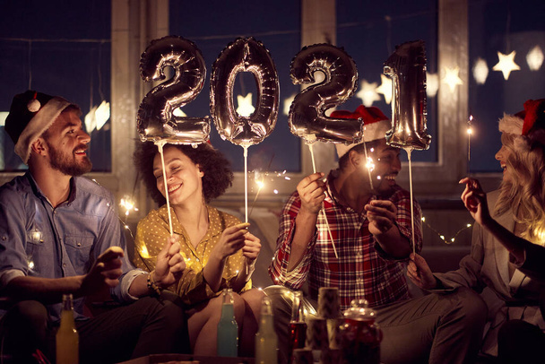 Cheerful couples having good time together at New Year eve home party in festive atmosphere. New Year, home party, friends time together - Фото, изображение