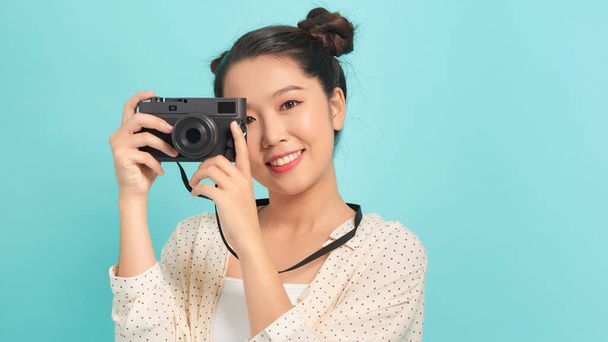 Pretty cool young woman model with retro film camera over blue background - Фото, зображення