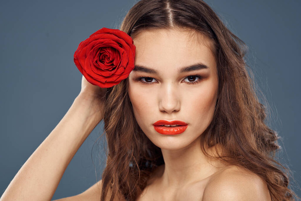 woman with a rose in her hands naked shoulders evening makeup red lips - Foto, Imagem