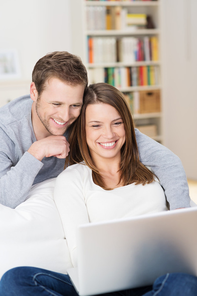 Young couple grinning at content on the laptop - Foto, immagini