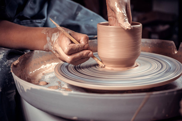 La clase maestra sobre el modelado de la arcilla a la rueda de alfarero En el taller de cerámica - Foto, Imagen