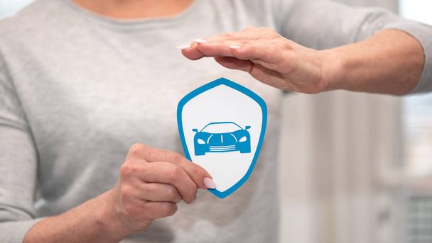Концепция страхования спортивных автомобилей с бумажным щитом, удерживаемым женской рукой - Фото, изображение