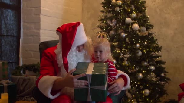 Добрий Санта Клаус дарує дівчині подарунок. - Кадри, відео