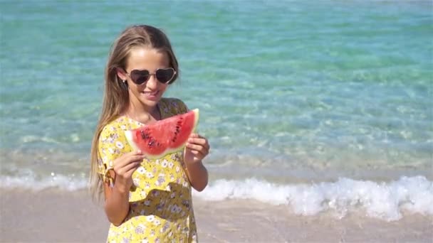 gelukkig meisje het hebben van plezier op het strand en het eten van watermeloen - Video