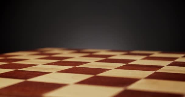 belo tabuleiro de xadrez de madeira em um fundo preto - Filmagem, Vídeo