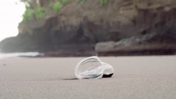 Steekclose-up van enkelvoudige, niet afgewerkte, verfrommelde plastic beker die door onzorgvuldig mens aan de kust wordt gegooid - Video