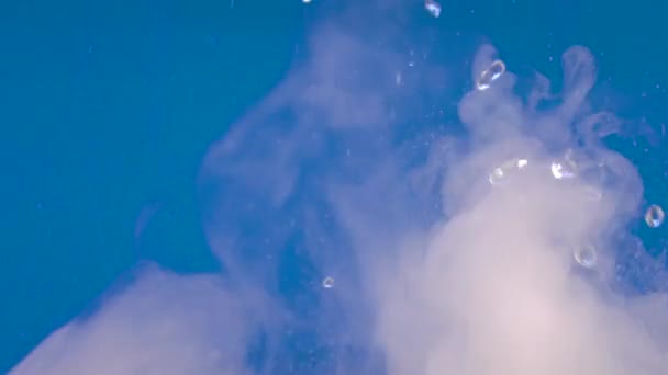 Ontspannende video 's met spatten en druppels water met mist of rook op een blauwe achtergrond met de mogelijkheid om lus. Water spatten in close-up.Swirl druppelen en spring water in beweging.Chemische reactie water - Video