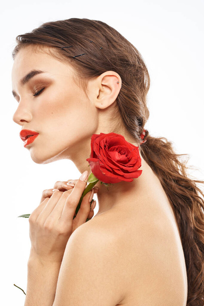 Красивая женщина с красной розой возле лица макияж голые плечи портрет - Фото, изображение